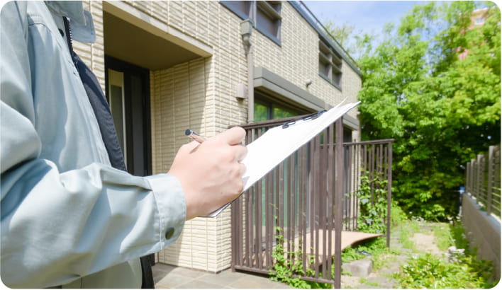 お庭を訪問して現地確認と見積もりを行うスタッフ
