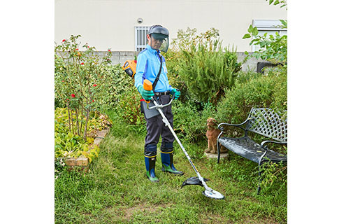 広いお庭で草刈りを行うスタッフ